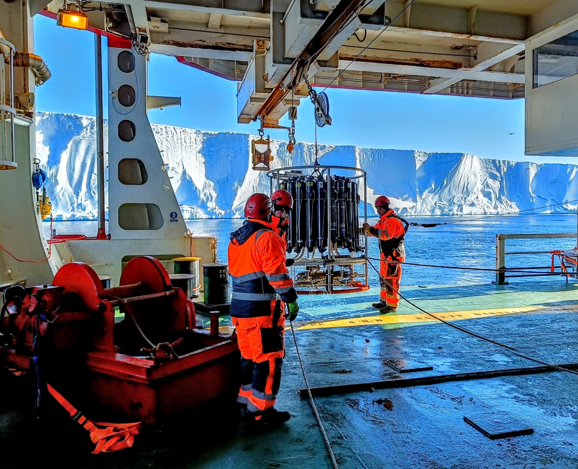 Scientists deploying a CTD rosette from the side of a ship