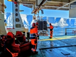 Scientists deploying a CTD rosette from the side of a ship